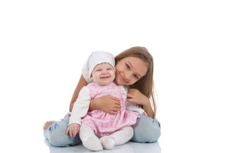 two caucasian girl children sitting on floor isolated over whiteの写真素材