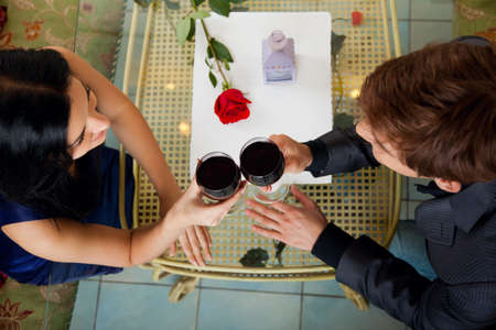 Young happy couple romantic date drink glass of red wine at restaurant