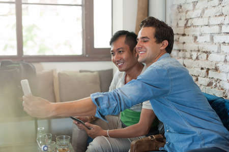 Two Men Friends Taking Selfie Photo Smart Phoneの写真素材