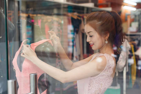 Asian woman shopping choosing fashion dress shopの写真素材