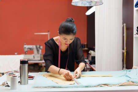 Asian woman tailor fashion clothes dress designer working with fabric