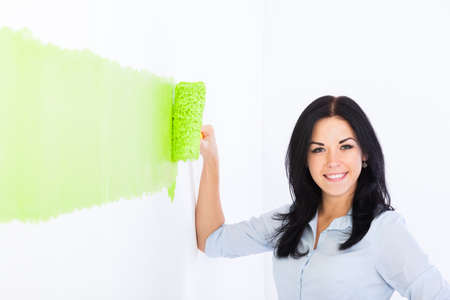 young couple paint wall green brush, at home renovate