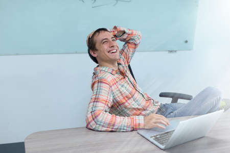 Success excited business man happy smile sitting office desk, young businessman laughing fun