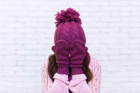 Attractive Teenage Girl Holding Arms Covering Face Emotional Over White Brick Backgroundの写真素材