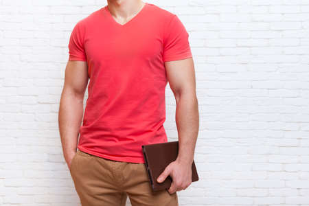 Unrecognizable Man Holding Tablet Computer Over White Brick Wall
