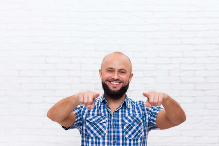 Casual Bearded Man Smiling Point Fingers At You Over White Brick Wall