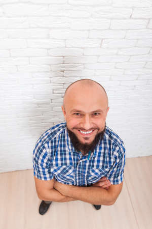 Casual Bearded Business Man Smiling Folded Hands Top View Office Over White Brick Wallの写真素材
