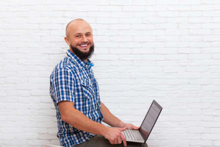 Casual Bearded Business Man Sitting Office Hold Laptop Online Communication Over White Brick Wall