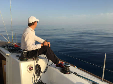 Young man sailing yacht yachtsman holding hands rope vacation sail holidays people travel