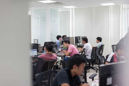 Asian Software Developers Office Team Sitting At Desk Working Laptop Computer Business People Group...