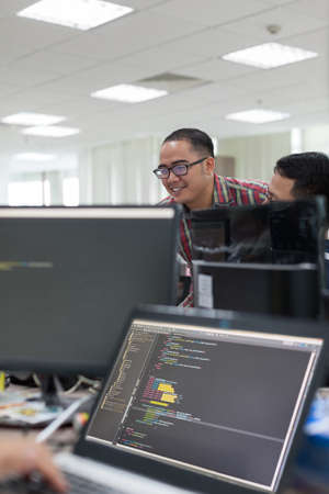 Asian Colleagues Software Developers Team Desk Working Laptop Computer Business People Real Officeの写真素材