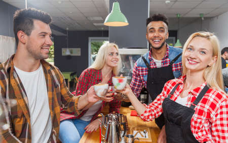 Barista serving clients give cup tea coffee shop bar counter, mix race man and woman happy smile to customerの写真素材