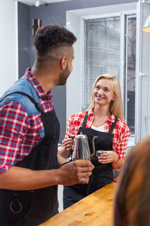Barista serving clients give cup coffee shop bar counter, mix race man and woman happy smile to customer top angle above viewの写真素材