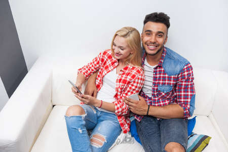 Couple sitting sofa love embrace mix race man womanの写真素材