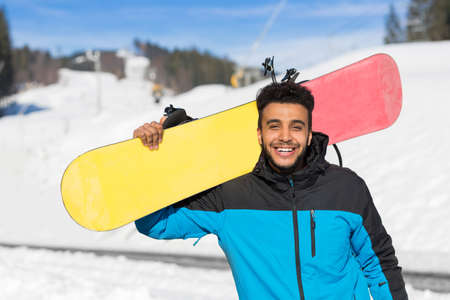 Hispanic Man Hold Snowboard Ski Resort Winter Snow Mountain Cheerful Happy Smiling Guy Holiday Extreme Sport Vacationの写真素材