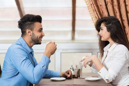 Business Man And Woman Sitting At Table Drinking Coffee, Young Couple Dating Hold Cup Cafe Interior