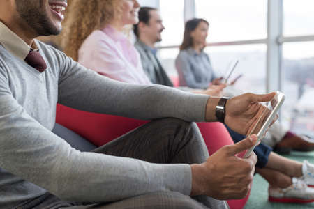 Businesspeople In Coworking Center Business Team Coworkers Using Tablet Computers Sitting in front Panoramic Window Modern Officeの写真素材