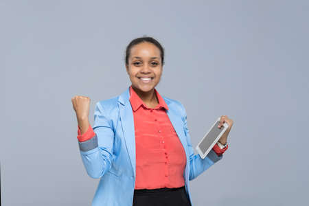 Happy Young Business Woman Hold Tablet Computer Excited African American Girl Businesswoman Isolated Over Gray Backgroundの写真素材