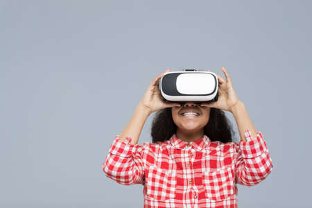 Young Woman Wear Virtual Reality Digital Glasses African American Girl Happy Smile Isolated Over Gray Backgroundの写真素材