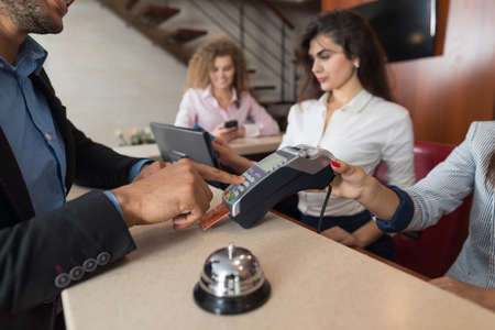 Business Man Hotel Pay For Room With Credit Card Woman Receptionist Registration At Reception Counter Checking Inの写真素材