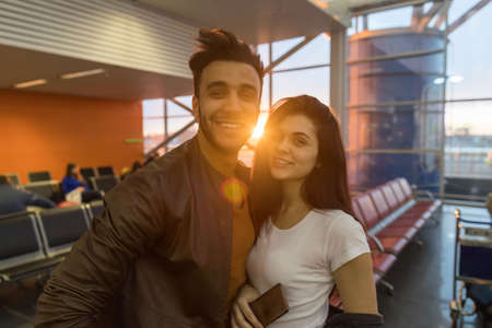 Young Couple In Airport Lounge Waiting Departure Happy Smile Hispanic Man And Woman Flight