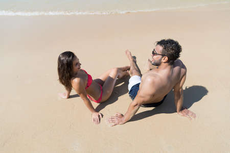 Couple On Beach Summer Vacation, Young People Sitting On Sand, Man Woman Sea Ocean Holiday Travelの写真素材