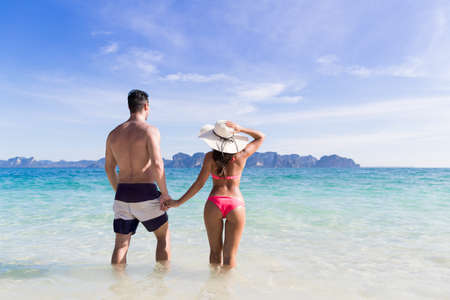 Young People On Beach Summer Vacation, Couple Walking Seaside Blue Water Sea Ocean Holiday Travelの写真素材