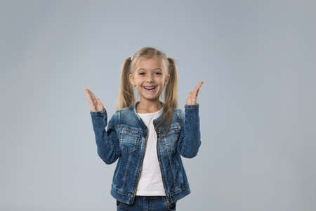 Excited Little Teenage Girl Hold Hands Up, Small Happy Smiling Child Isolated Over Gray Background