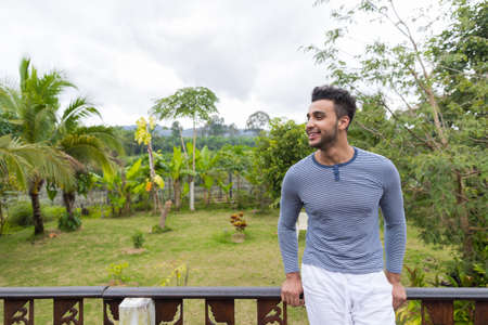 Happy Smiling Latin Man Over Green Tropical Rain Forest Landscape, Hispanic Guy Looking Asideの写真素材