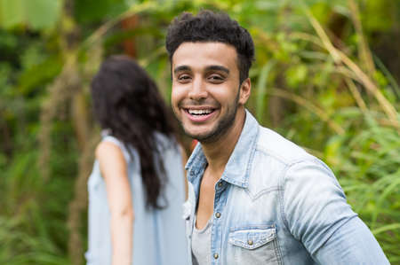 Young Couple Hispanic Man And Woman Walking Tropical Forest Holiday Happy Smiling Summer Vacation Travelの写真素材