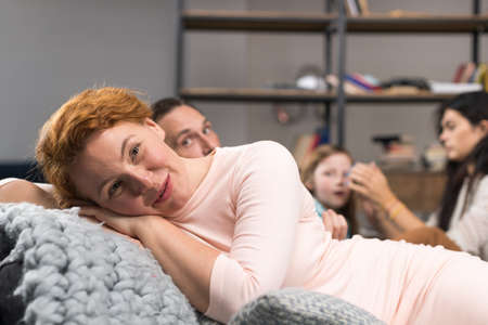 Happy Smiling Mother Lying On Couch Over Family Communication Background, Parents Spending Time With Children, Parents Spending Time With Children In Living Roomの写真素材