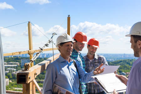Builders Team Meeting With On Construction Site Discussing Project Plan With Architect Contractor Business Manの写真素材