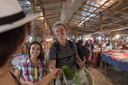 Tourists On Tropical Street Market In Thailand Young People Buying Fresh Fruits And Vegetables On Asian Bazaarの写真素材
