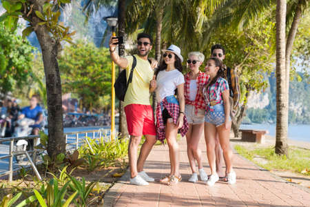 Young People Group On Beach Taking Selfie Photo On Cell Smart Phone Summer Vacation, Happy Smiling Friends Sea Holiday Ocean Travelの写真素材