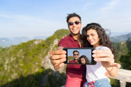 Young Couple Mountain View Point Happy Smiling Man And Woman Taking Selfie Photo On Cell Smart Phone...