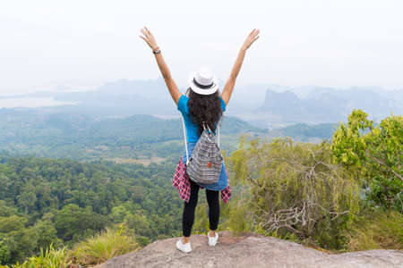 Tourist Girl With Backpack Standing On Mountain Top Raised Hands Back Rear View Enjoy Beautiful Landscape, Young Woman On Hikeの写真素材