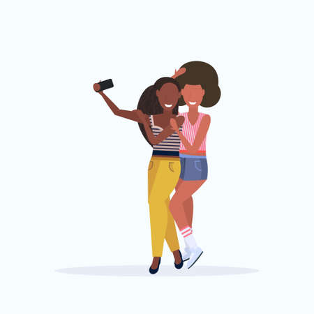 two women taking selfie photo on smartphone camera african american female cartoon characters standing together posing on white background flat full length vector illustrationのイラスト素材