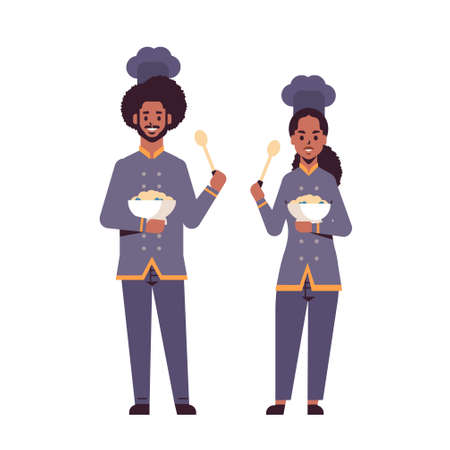 cooks couple professional chefs holding plates with porridge and spoons african american man woman restaurant workers in uniform tasting dishes cooking food concept flat full length vector illustrationのイラスト素材