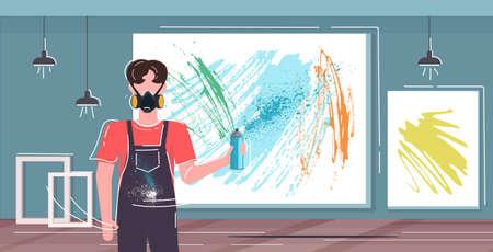 artist in respiratory mask using aerosol spray man painter standing in front of picture on wall art...