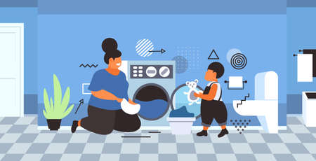 family doing housework mother with son loading clothes in washing machine cleaning service concept...