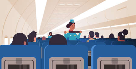stewardess explaining passengers how to use seat belt fastening in emergency situation african...