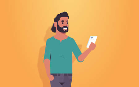 man holding cellphone arab guy using smartphone mobile app social media communication concept male cartoon character portrait horizontal vector illustrationのイラスト素材