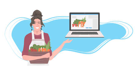woman gardener with basket full of fresh vegetables using laptop healthy nutrition online food orderのイラスト素材