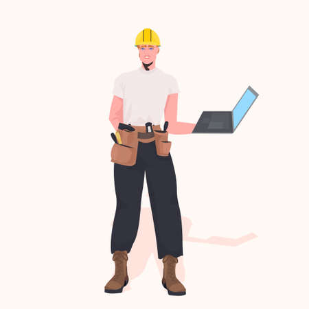 foreman in helmet using laptop working at construction site repair service concept