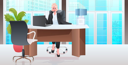 blonde businesswoman sitting at workplace business woman leader working in office full lengthのイラスト素材
