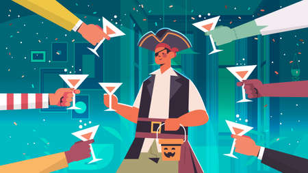 hands holding cocktails around man in pirate costume happy halloween holiday celebration bar party...