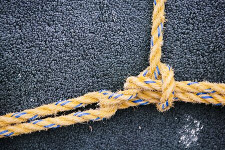 Yellow nylon line tied in a knot on dark backgroundの写真素材