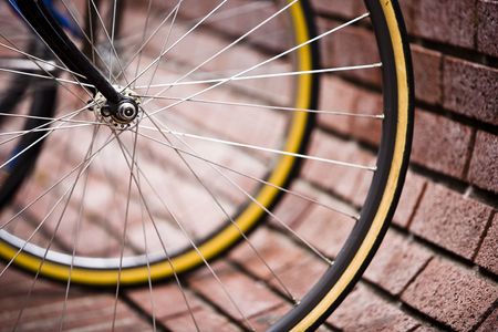 Road bicycle parked against a curved brick wall.