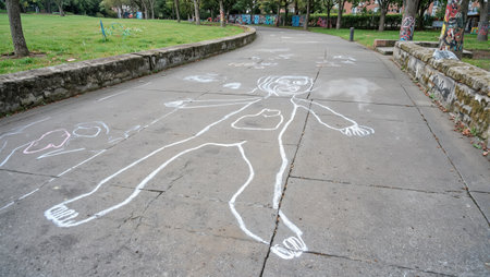 Realistic chalk outline on urban sidewalk with graffiti and trash nearbyの素材