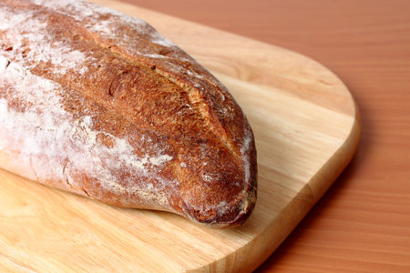 a loaf of bread fresh roasted on wooden plate